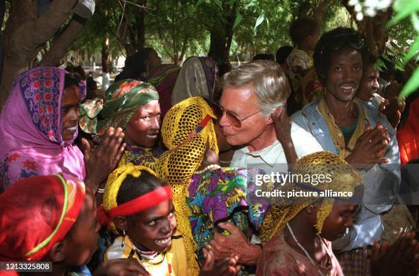 Umringt von Dorfbewohnern küßt Schauspieler Karlheinz Böhm am 28.1.1996 zur Begrüßung eine Frau im äthiopischen Erer-Tal. Seine 1981 ins Leben...