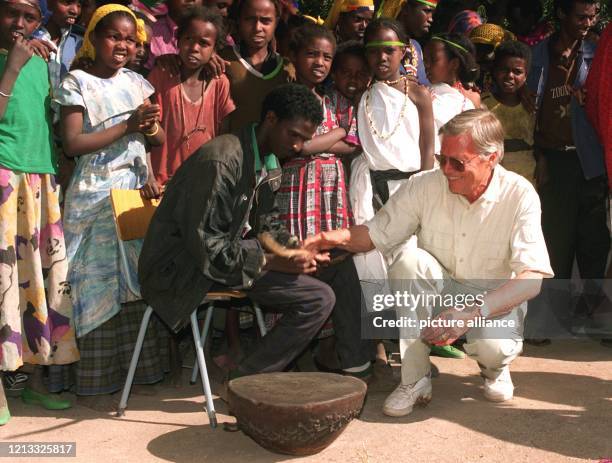 Umringt von Kindern übt Schauspieler Karlheinz Böhm mit Hilfe eines Dorfbewohners am 28.1.1996 im äthiopischen Erer-Tal das Trommeln. Seine 1981 ins...