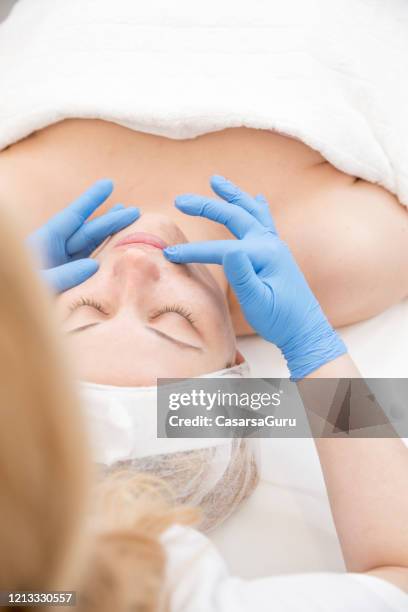 beautician preparing woman's skin for facial treatment - stock photo - vaseline stock pictures, royalty-free photos & images