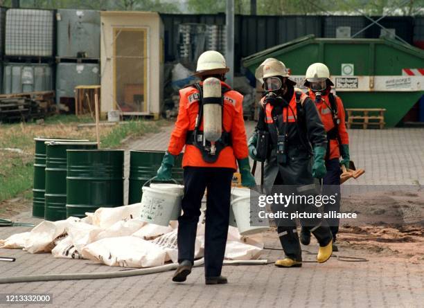 Feuerwehrmänner in Atemschutzgeräten räumen auf dem Gelände einer Chemiefirma in Geesthacht auf. In dem Unternehmen war am 24.4.1996 ein Rührkessel...