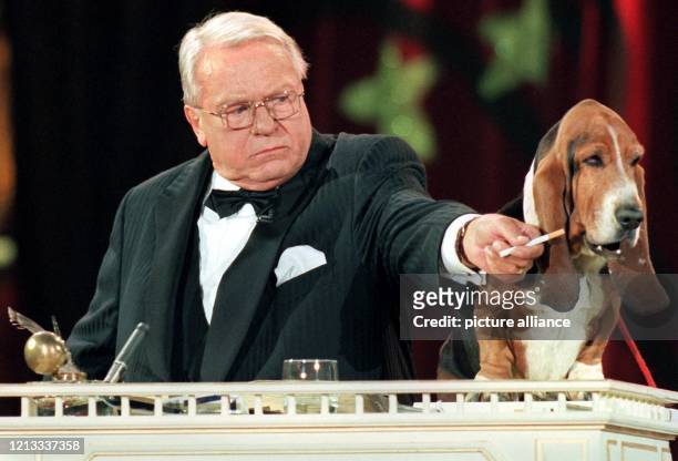 Nichraucher. Der Schauspieler Günter Strack bietet dem "sprechenden" Hund Oscar während der Generalprobe zu "Stars in der Manege" im Cicus Krone am...