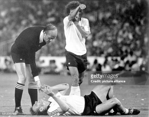 Der italienische Schiedsrichter Paolo Casarin schaut nach dem mit schmerzverzerrtem Gesicht verletzt am Boden liegenden deutschen Verteidiger...