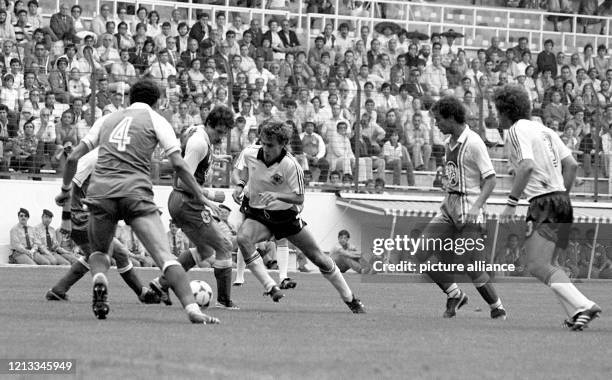 Der deutsche Mittelfeldspieler Pierre Littbarski versucht sich durch die vielbeinige algerische Abwehr durchzudribbeln. Sein Teamgefährte Paul...