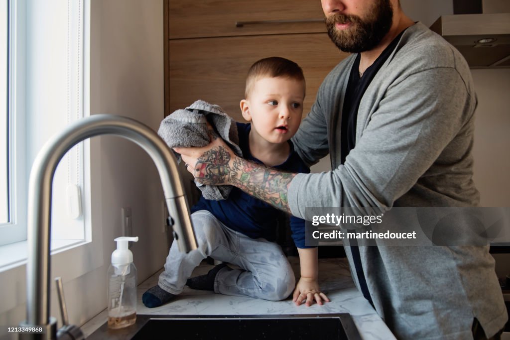 Father teaching young children how to wash their hands in quarantine isolation Covid-19