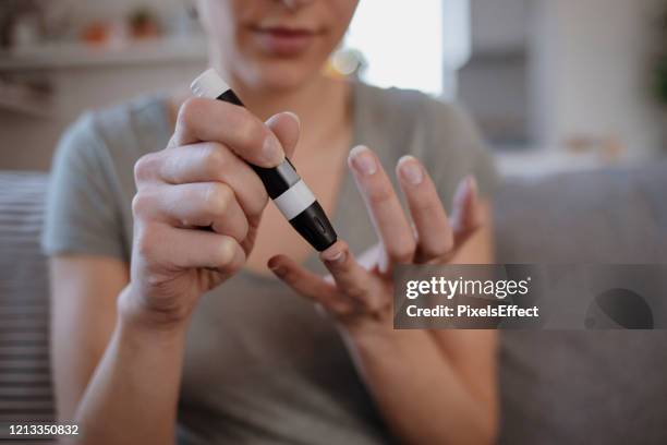 women checking blood sugar levels by glucose meter - glycemia stock pictures, royalty-free photos & images