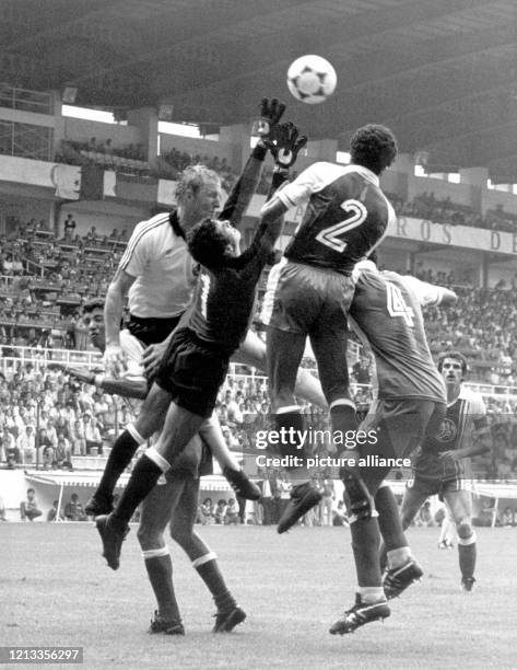 Der deutsche Stürmer Horst Hrubesch kommt mit dem Kopf nicht an den Flankenball. Mit ihrem gehen zur Kugel: der algerische Torhüter Mehdi Cerbah und...