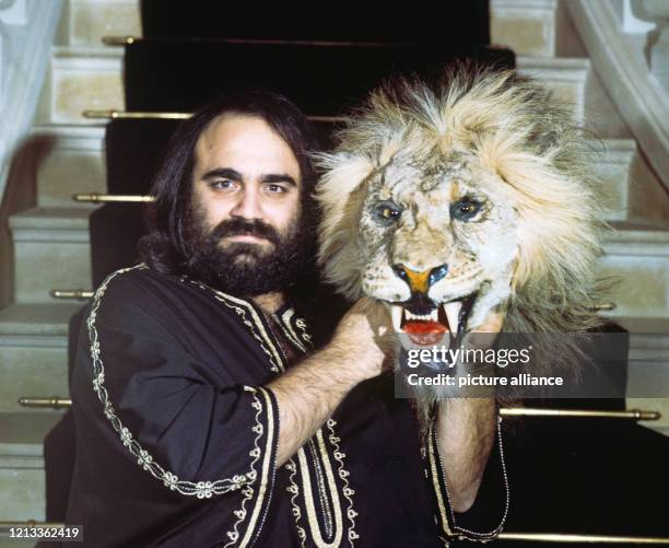 Der griechische Schlagersänger Demis Roussos , posiert auf einer Treppe mit einem Löwenfell, aufgenommen im November 1976 in seinem Haus in der Nähe...