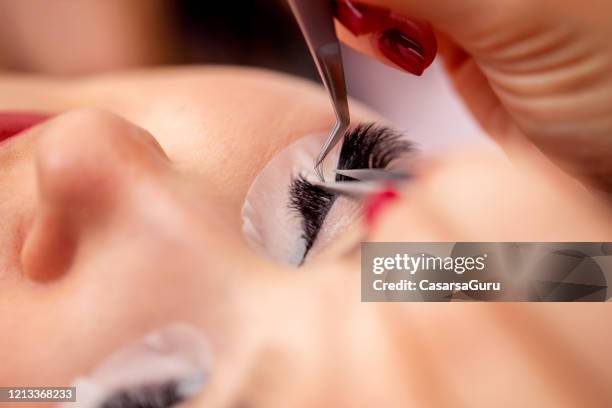 nahaufnahme der falschen wimpernapplikation mit pinzette - stockfoto - wimpern stock-fotos und bilder