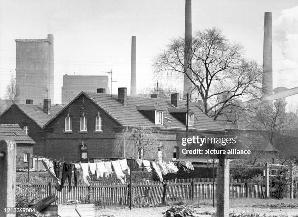 Wohnhäuser vor Schornsteinen in Eisenheim, der ältesten deutschen Arbeitersiedlung in Oberhausen in Nordrhein-Westfalen, aufgenommen am . Foto:...