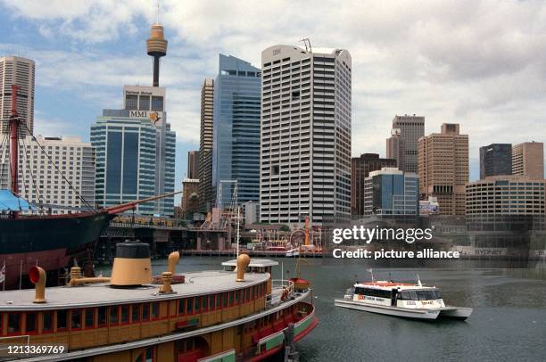 Blick vom Festival- und Marktplatz am Darling Harbour im australischen Sydney über das Hafenbecken auf die Hochhäuser in der Innstadt mit dem Sydney...