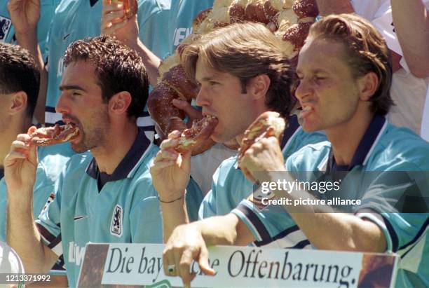 Beim Foto-Termin des TSV München 1860 am 13.7.1998 in München essen die Spieler Miroslav Stevic, Harald Cerny, Horst Heldt Brezeln.