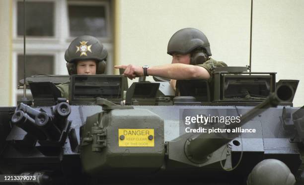 Prinz Harry sitzt bei seinem Besuch der britischen Truppen in Bergen-Hohne in Niedersachsen in einem Panzerfahrzeug der Armee neben einem Soldaten ....