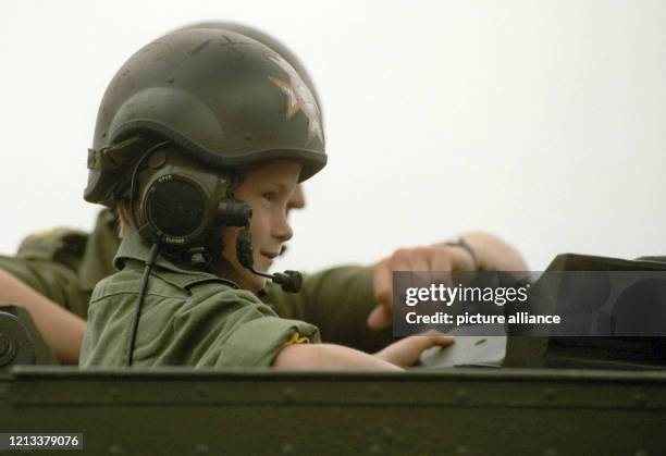 Prinz Harry sitzt bei seinem Besuch der britischen Truppen in Bergen-Hohne in Niedersachsen in einem Panzerfahrzeug der Armee neben einem Soldaten ....