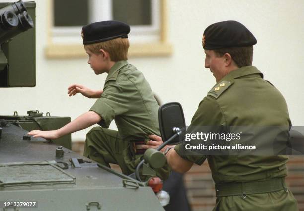 Prinz Harry klettert bei seinem Besuch der britischen Truppen in Bergen-Hohne in Niedersachsen auf ein Panzerfahrzeug der Armee. Er wird von einem...