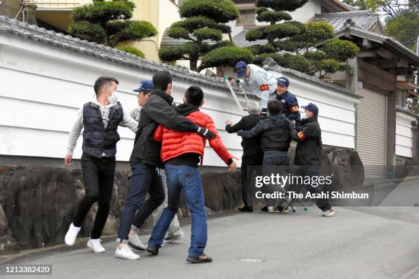 Members of yakuza syndicate Dojinkai wearing masks resist the police raid at the headquarters on March 13, 2020 in Kurume, Fukuoka, Japan. Fukuoka...