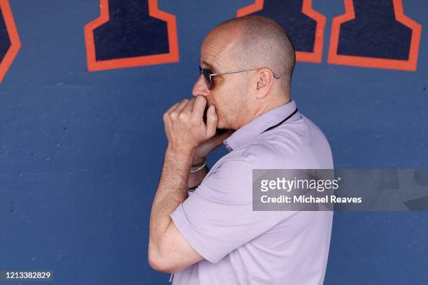 New York Yankees general manager Brian Cashman talks on the phone prior to a Grapefruit League spring training game between the Washington Nationals...