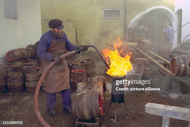 In Rauchschwaden gehüllt verrichten die Arbeiter der Klosterbrauerei Reutberg bei Bad Tölz in Oberbayern am ihr Werk: sie pichen die Holzfässer, in...