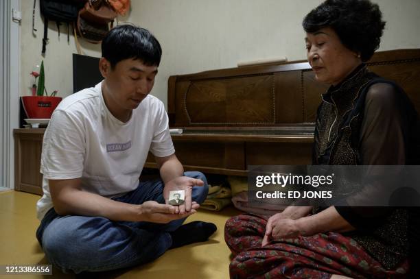 This photo taken on May 14, 2020 shows Jung Ho-hwa holding the only remaining photo of his father Jung Ki-young, who disappeared during the Gwangju...