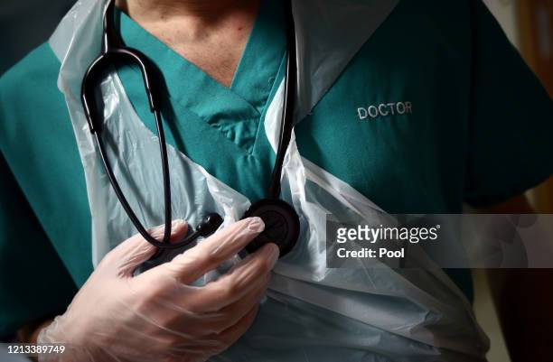 Junior Doctor holds his stethoscope during a patient visit on Ward C22 at The Royal Blackburn Teaching Hospital in East Lancashire, during the...