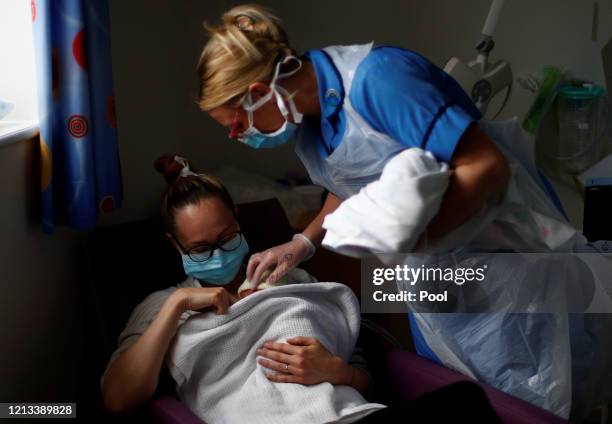 Neonatal Nurse Kirsty Hartley checks on premature baby Theo Anderson whilst he's in the arms of his mother Kirsty Anderson in the Neonatal Intensive...