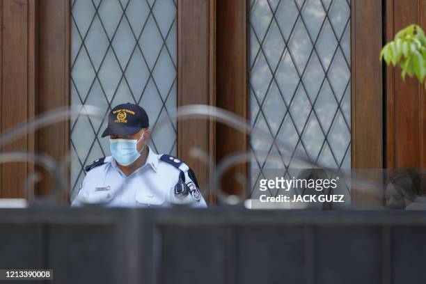 An Israeli policeman stands guard in front of the gated house of the Chinese ambassador where he was found dead, in Herzliya on the outskirts of Tel...