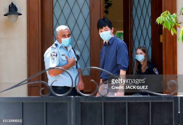 Members of the Israeli police talk to people at the gated house of the Chinese ambassador where he was found dead, in Herzliya on the outskirts of...