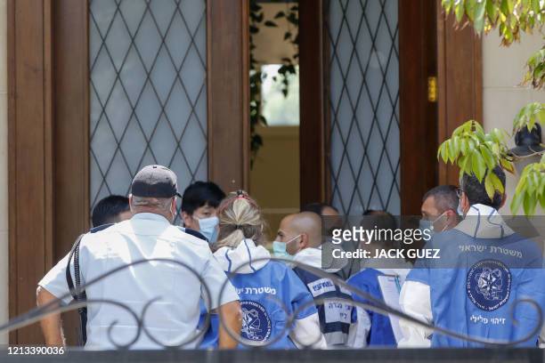 Israeli police and forensic experts gather in front of the residence of Israel's Chinese ambassador on the outskirts of Tel Aviv, after he was found...
