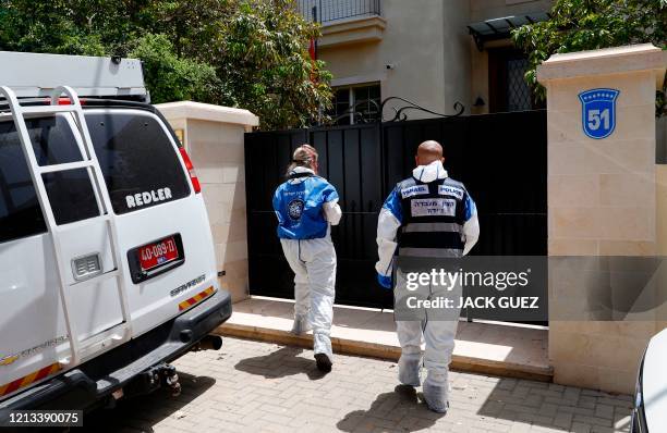 Israeli police forensics experts enter the gated house of the Chinese ambassador where he was found dead, in Herzliya on the outskirts of Tel Aviv,...