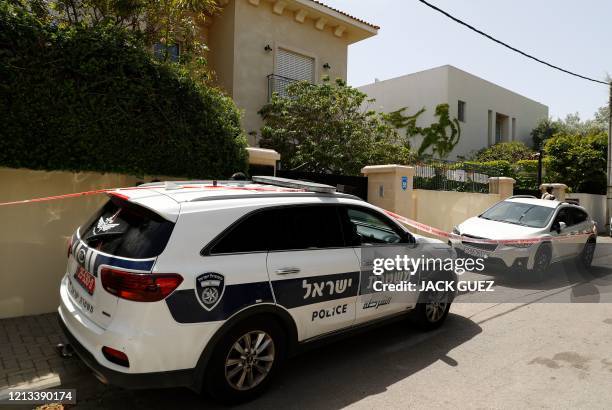 Police cars and a red ribbon block the entrance to the residence of Israel's Chinese ambassador on the outskirts of Tel Aviv, after he was found dead...