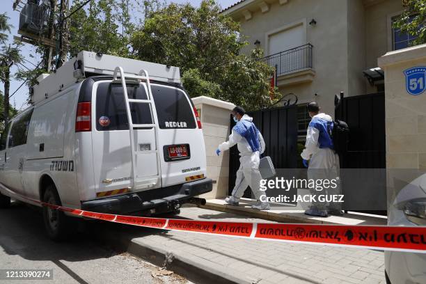 Red tape blocks the entrance to the residence of Israel's Chinese ambassador on the outskirts of Tel Aviv, as forensic experts walk out, after he was...