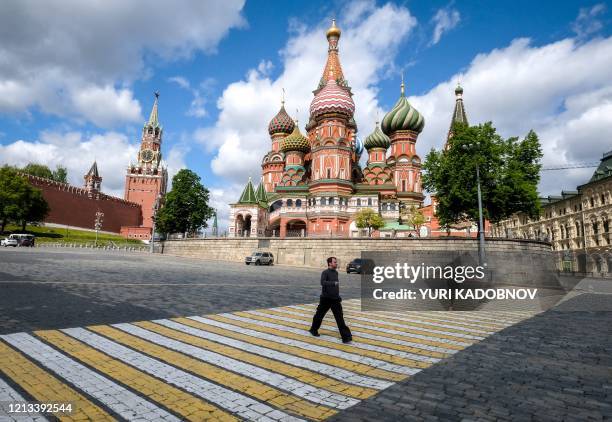 Man walks in front of Saint Basil Cathedral in central Moscow on May 17 during a strict lockdown in Russia to stop the spread of the novel...