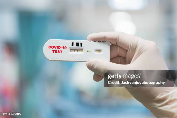 doctor hand holding positive coronavirus or covid-19 rapid test - covid 19 stock pictures, royalty-free photos & images