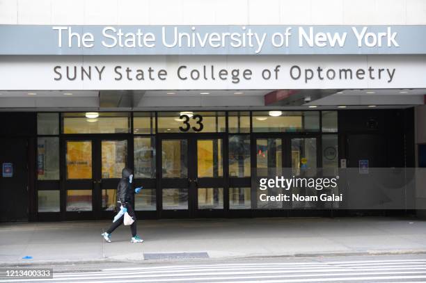 Person is seen wearing a protective face mask outside The State University of New York as the coronavirus continues to spread across the United...