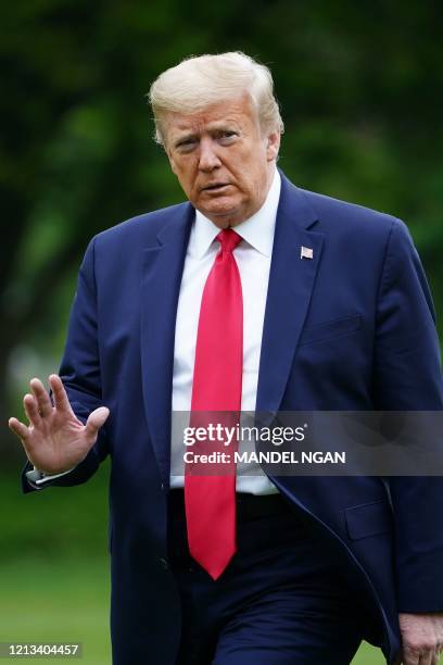 President Donald Trump walks across the South Lawn upon return to the White House in Washington, DC on May 17, 2020. - President Trump returned to...