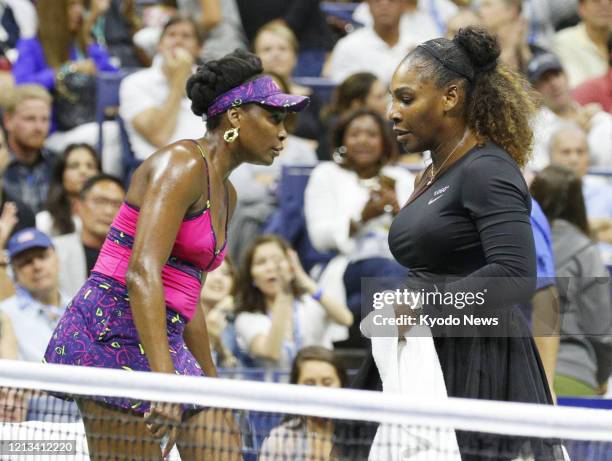 Photo taken Aug. 31 shows Serena Williams of the United States and her older sister Venus Williams during a third round match of the U.S. Open tennis...