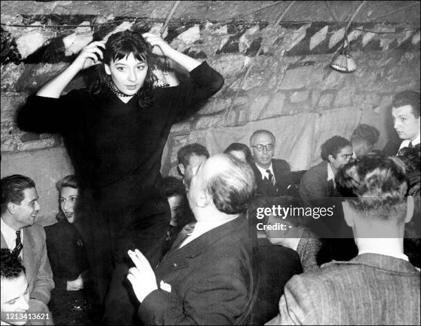 La chanteuse française Juliette Gréco discute avec un personne non identifiée dans un cabaret parisien en 1957. Née le 07 février 1927 à Montpellier,...