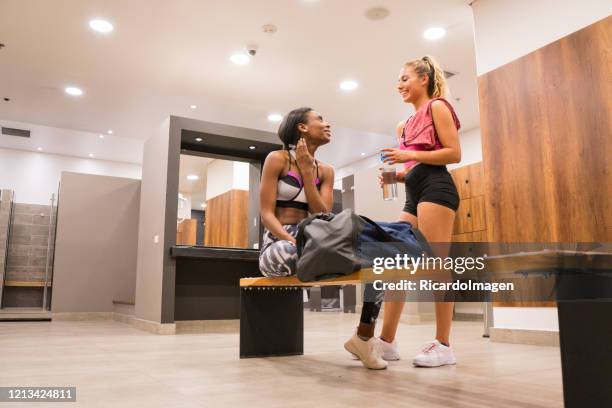 femmes parlant après l’entraînement dans le vestiaire de gymnastique - vestiaires casier sport photos et images de collection