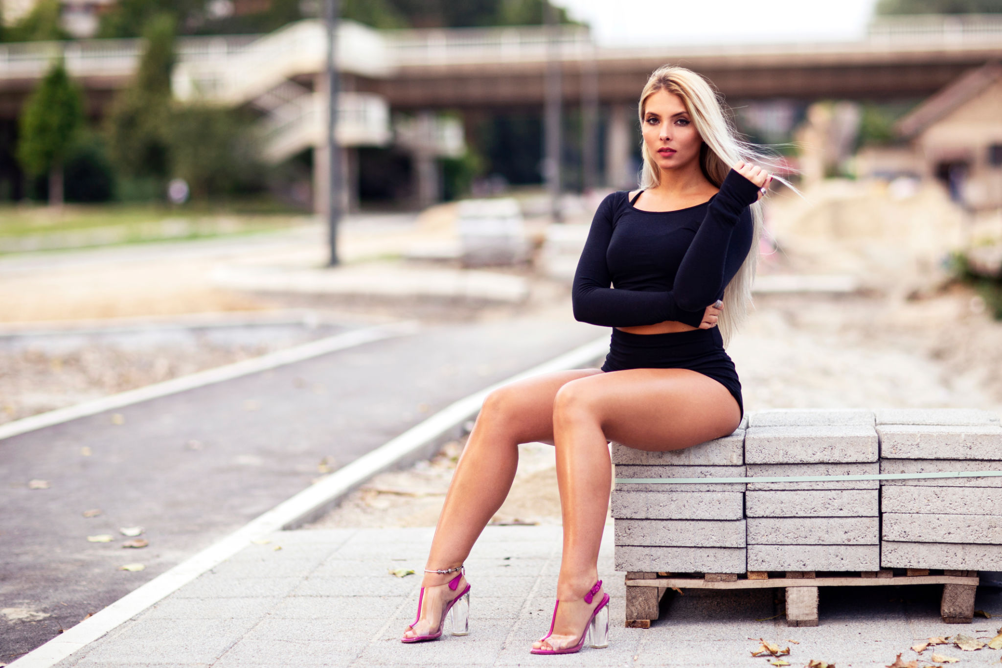 Portrait of young blonde long hair girl sitting on the street Portrait of young blonde long hair girl sitting on the street