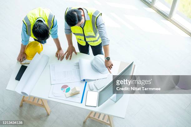 top view of the chief architect and engineer working, meeting, discussing,designing, planing, measuring layout of building blueprints for construction building. - asian architect 40 imagens e fotografias de stock