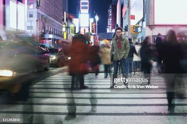 man standing in busy intersection in times square - new york person strasse stock-fotos und bilder