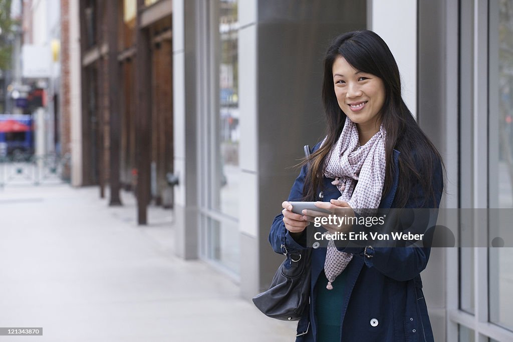 Woman with handheld device at shopping area