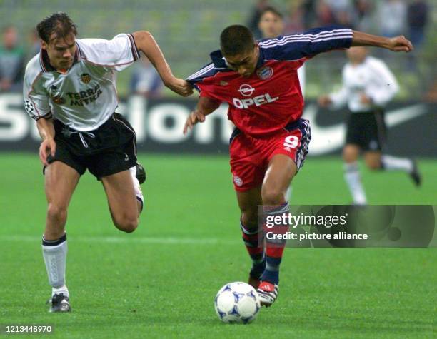 Bayerns brasilianischer Stürmer Giovane Elber läuft auf das Tor des FC Valencia zu und wird vom schwedischen Valencia-Abwehrspieler Joachim Björklund...