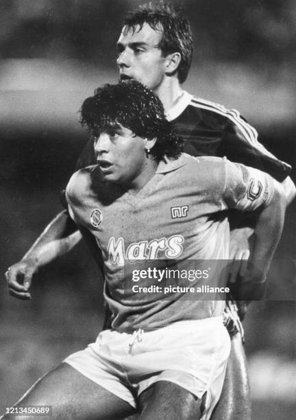 Der argentinische Fußballstar Diego Armando Maradona vom SSC Neapel wird vom Bayern-Gegenspieler Hansi Flick eng gedeckt am 5.4.1989 im San...