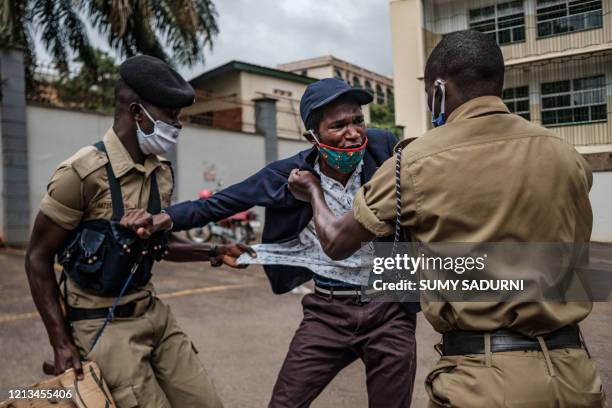 Protester is arrested by police officers as Stella Nyanzi , a prominent Ugandan activist and government critic, organized a protest for more food...