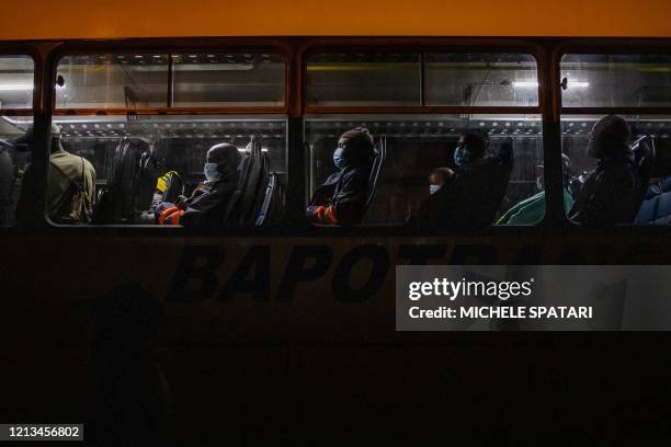 Mine workers en route to their evening shift at the Sibanye-Stillwater platinum mine wait on board of a company bus at the Wonderkop taxi rank in...