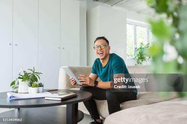 leende ung man som arbetar på digital surfplatta på kontoret - asian young executive laughing office bildbanksfoton och bilder