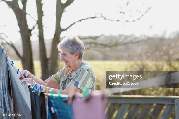 pegging out the washing - clothesline stock pictures, royalty-free photos & images