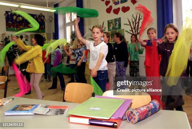 Schüler der Klasse 3a der Regensburger Von-der-Tann-Schule schwingen am zu flotter Musik bunte Tücher im Takt ihrer rhythmischen Körperbewegungen....