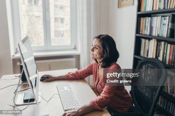 woman working at computer at home - freelance work candid stock pictures, royalty-free photos & images