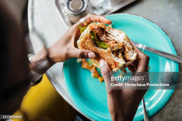 close up of woman eating vegan meal - veggie burger bildbanksfoton och bilder